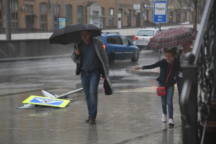 Москва.   Поваленный ураганом дорожный знак на одной из улиц города.