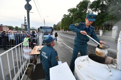 Москва.  Сотрудники МЧС и  православные добровольцы  раздают горячий чай на Пречистенской набережной, где стоит очередь  к Храму Христа Спасителя  с мощами святителя Николая Чудотворца.