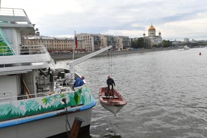 Москва.  Рабочий в лодке  поднимается на борт  теплохода `Валерий Брюсов` , на котором идет демонтаж оборудования.