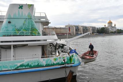 Москва.  Рабочий в лодке  поднимается на борт  теплохода `Валерий Брюсов` , на котором идет демонтаж оборудования.