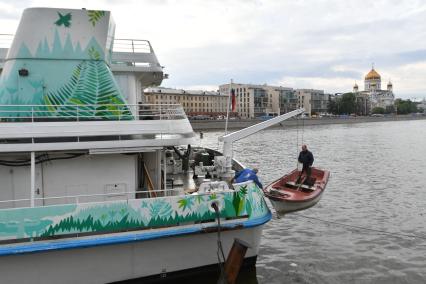 Москва.  Рабочий в лодке  поднимается на борт  теплохода `Валерий Брюсов` , на котором идет демонтаж оборудования.