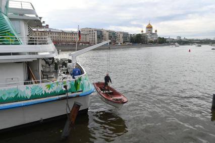 Москва.  Рабочий в лодке  поднимается на борт  теплохода `Валерий Брюсов` , на котором идет демонтаж оборудования.