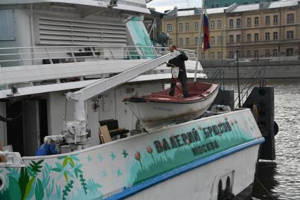 Москва.  Рабочий в лодке  поднимается на борт  теплохода `Валерий Брюсов` , на котором идет демонтаж оборудования.