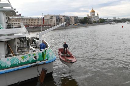 Москва.  Рабочий в лодке  поднимается на борт  теплохода `Валерий Брюсов` , на котором идет демонтаж оборудования.