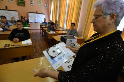 Москва. Педагог вскрывает  конверт с заданием ЕГЭ (единый государственный экзамен) по профильной математике  в  школе #7  на улице Крупской .