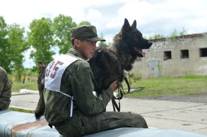 Хабаровск. Военнослужащий с собакой на полигоне во время соревнований кинологов `Верный друг` .