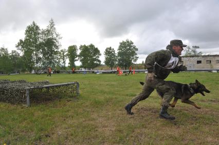 Хабаровск. Военнослужащий с собакой на полигоне во время соревнований кинологов `Верный друг` .