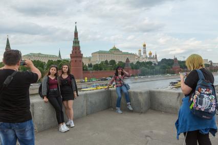 Москва.  Туристы фотографируются на Большом Каменном мосту.