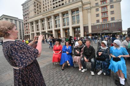 Москва.Женщины в  платьях в стиле `ретро` фотографируются  на  Манежной площади, где проходит фестиваль`Времена и эпохи`.