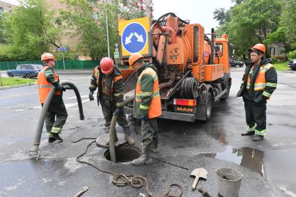 Москва.  Сотрудники `Мосводостока` промывают водосток на Сущевском валу.