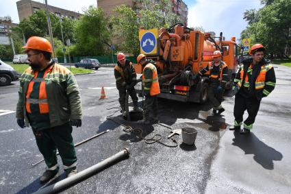 Москва.  Сотрудники `Мосводостока` промывают водосток на Сущевском валу.