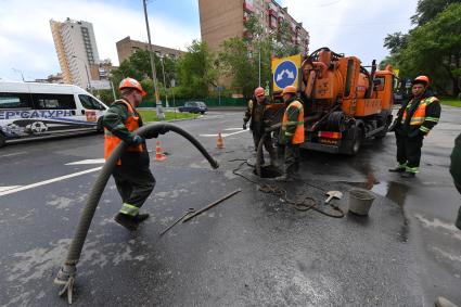 Москва.  Сотрудники `Мосводостока` промывают водосток на Сущевском валу.