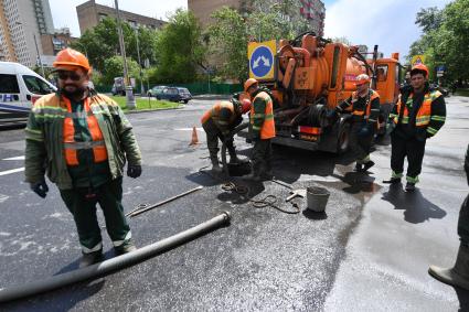 Москва.  Сотрудники `Мосводостока` промывают водосток на Сущевском валу.