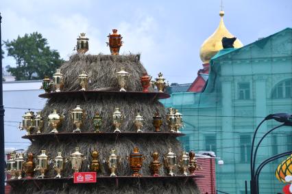 Москва.  Стог  сена с самоварами во время семейного фестиваля `Самоварфест` в саду `Эрмитаж` в рамках празднования Дня России.