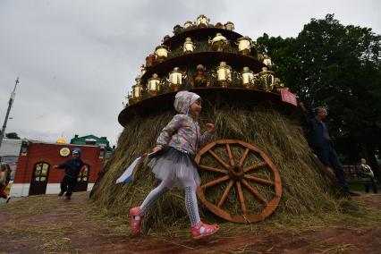 Москва.  Девочка у стога сена с самоварами во время семейного фестиваля `Самоварфест` в саду `Эрмитаж` в рамках празднования Дня России.