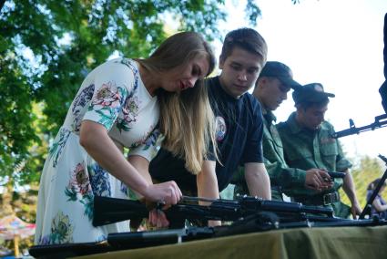 Екатеринбург. Девушка разбирает АК-74 (Автомат Калашникова) на стенде ДОСААФ, во время фестиваля Ural Music Night 2017