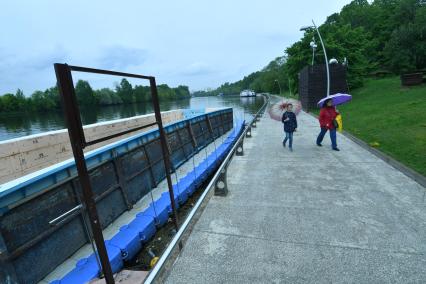 Москва.  Женщина с девочкой под зонтами на городском пляже в парке `Фили`.