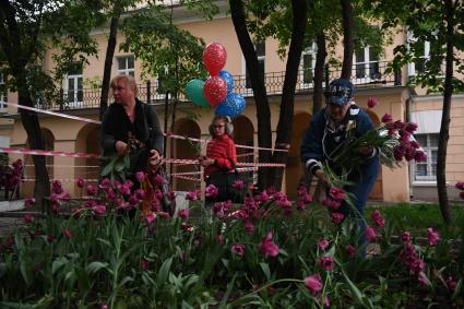 Москва. Горожане собирают тюльпаны, сломанные после урагана в сквере у дома Н.В. Гоголя на Никитском бульваре.