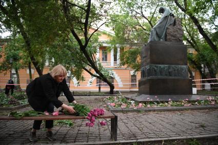 Москва. Женщина собирает тюльпаны, сломанные после урагана в сквере у дома Н.В. Гоголя на Никитском бульваре.