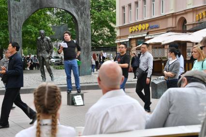 Москва.  Корреспондент `Комсомольской правды ` Павел Клоков читает стихи на старом Арбате  рядом с памятником Булату Окуджаве.