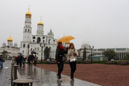 Москва. Туристы под зонтами на Ивановской площади  в Кремле.