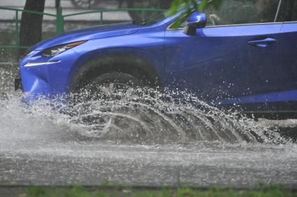 Москва.  Автомобили на подтопленной проливным дождем дороге.