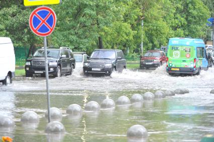 Москва.     Автомобили на подтопленной проливным дождем дороге.