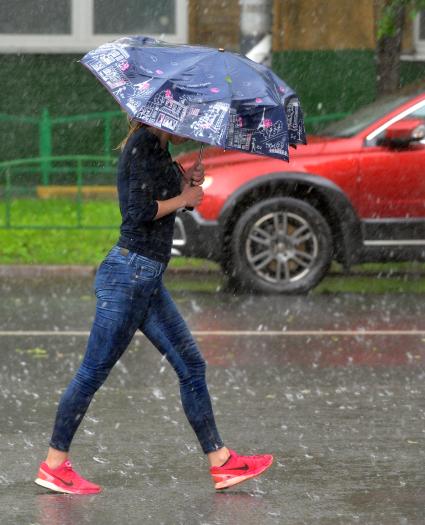 Москва.  Девушка с зонтом во время дождя на одной из улиц города.