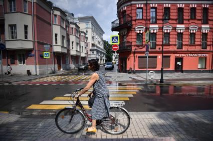 Москва. Девушка  едет на велосипеде по Малой Бронной.