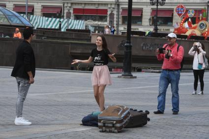 Москва. Девушка с чемоданами на Манежной площади.