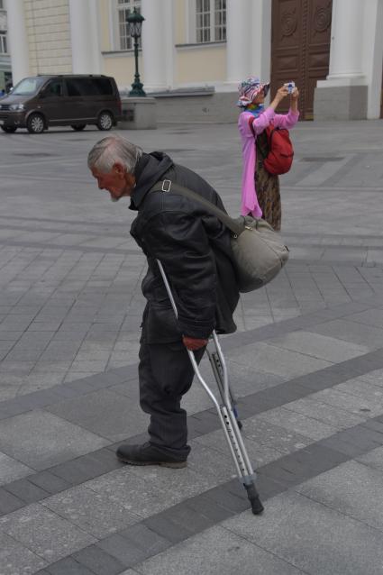 Москва. Мужчина на костылях у Александровского  сада.