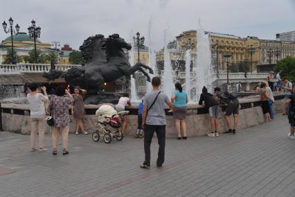 Москва. Прохожие у фонтана `Времена года`  в Александровском саду.