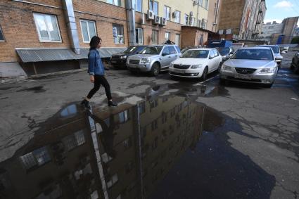 Москва. Девушка  обходит лужу.