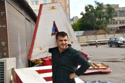 Москва. Мужчина держит макет буквы в постановочной фотосессии на тему изучения русского языка.