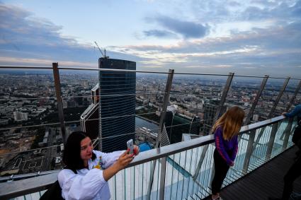 Москва.  Девушки делают селфи  на смотровой площадке башни `Око` делового центра   ` Москва -Сити`.