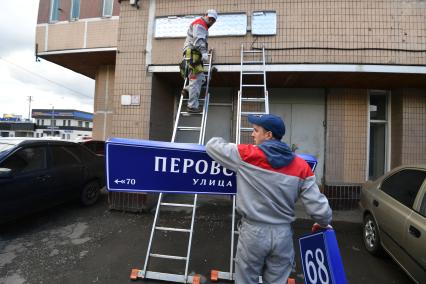 Москва. Рабочие устанавливают домовой указатель на здании Перовской улицы.