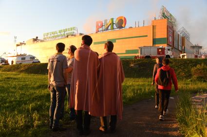 Москва. Сотрудники наблюдают за тушением пожара в здании торгового центра `РИО` на Дмитровском шоссе.