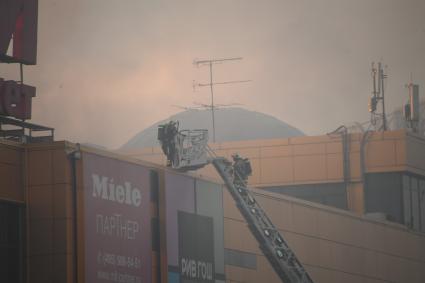 Москва.  Сотрудники противопожарной службы  во время тушения пожара  в здании торгового центра `РИО` на Дмитровском шоссе.