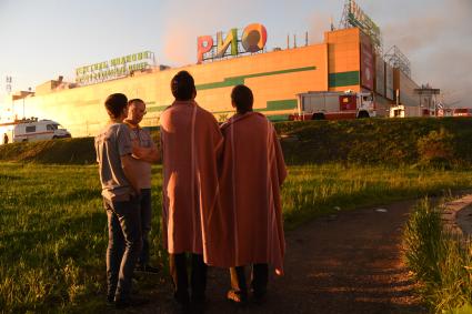 Москва.  Сотрудники наблюдают за тушением пожара  в здании торгового центра `РИО` на Дмитровском шоссе.