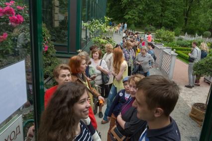 Москва. Посетители стоят в очереди в оранжерею, где расцвела кувшинка `Виктория амазонская` Аптекарского сада.