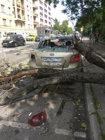 Москва.  Автомобиль, поврежденный упавшим деревом во время урагана на одной из улиц города.