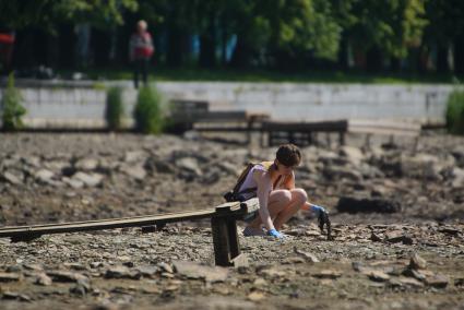 Екатеринбург. Волонтеры собирают мусор с берегов городского пруда обмелевших из-за сброса воды