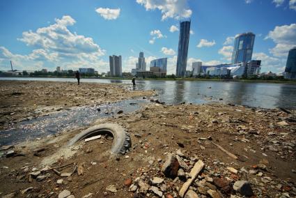 Екатеринбург. Волонтеры собирают мусор с берегов городского пруда обмелевших из-за сброса воды