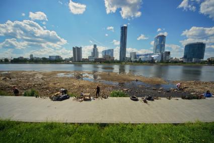 Екатеринбург. Волонтеры собирают мусор с берегов городского пруда обмелевших из-за сброса воды