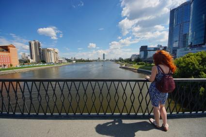 Екатеринбург. Девушка на мосту городского пруда с берегами обмелевшими из-за сброса воды