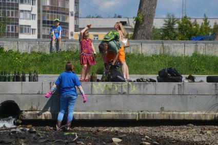 Екатеринбург. Волонтеры собирают мусор с берегов городского пруда обмелевших из-за сброса воды