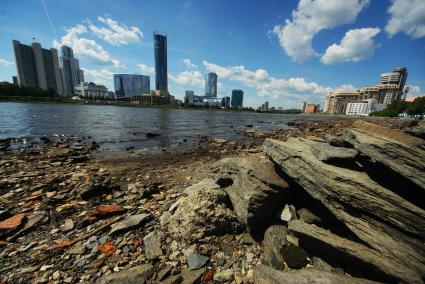 Екатеринбург. Волонтеры собирают мусор с берегов городского пруда обмелевших из-за сброса воды