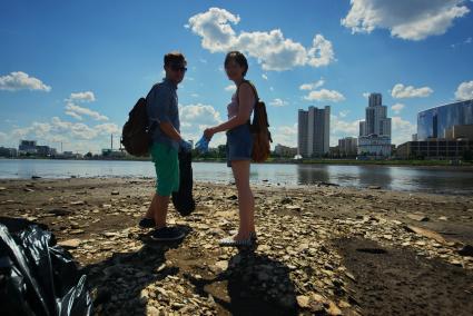 Екатеринбург. Волонтеры собирают мусор с берегов городского пруда обмелевших из-за сброса воды