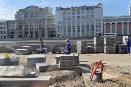 Москва. Рабочие укладывают плитку  на Москворецкой набережной .