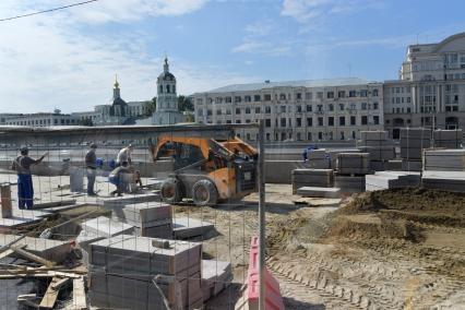 Москва. Рабочие укладывают плитку  на Москворецкой набережной .